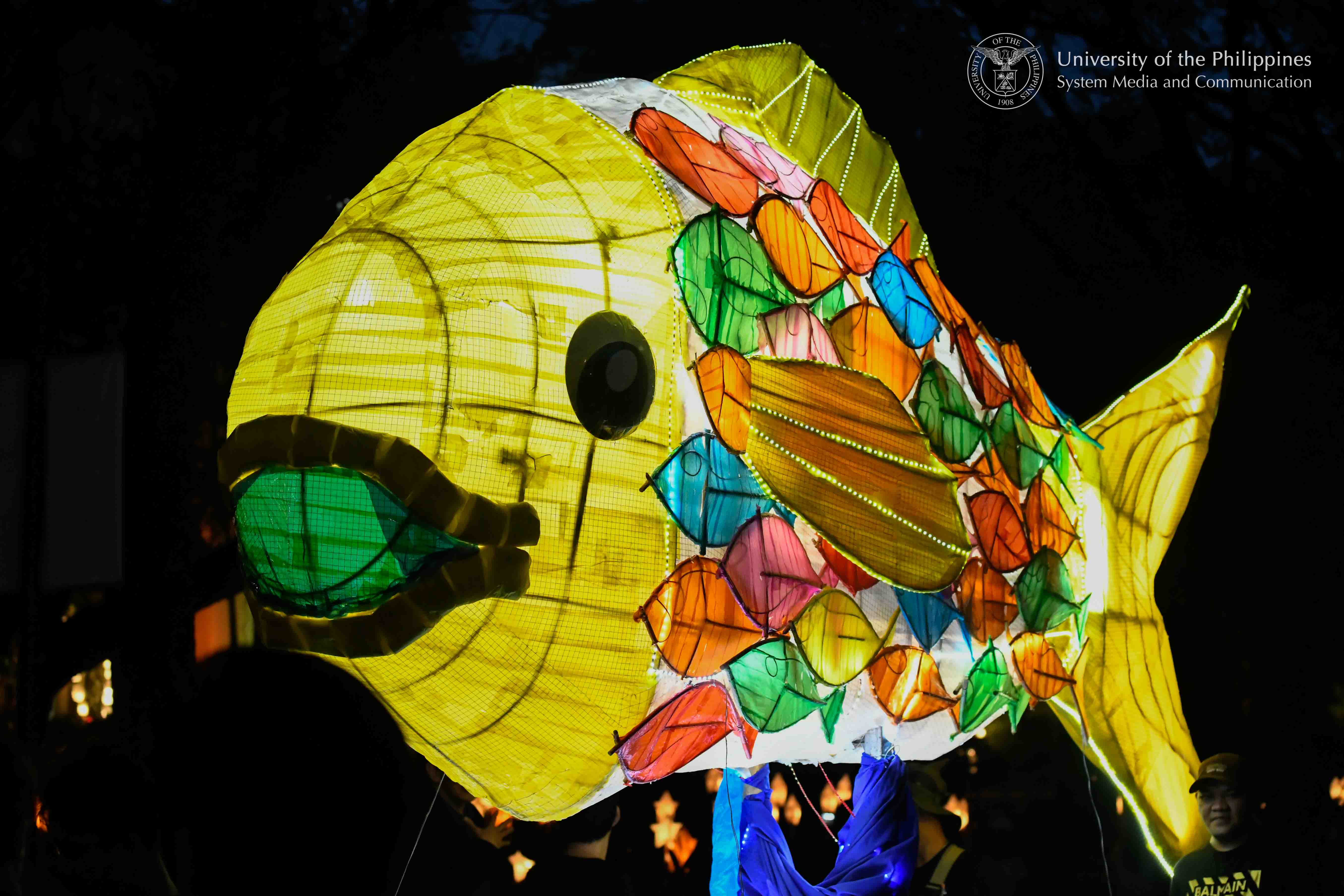 `A colorful school of fish coming together to become a large fish is the entry of the UP Diliman Asian Center for this year’s Lantern Parade. It highlights the importance of fish as a symbol in various Asian societies, as well as a symbolic call to unite for the protection of our country’s sovereignty and natural resources. Photo by Kevin Roque, UPS-MCO.`